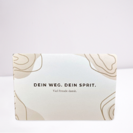 Braune abstrakte Kartenverpackung mit "Dein Weg. Dein Sprit. Viel Freude damit"-Schriftzug
